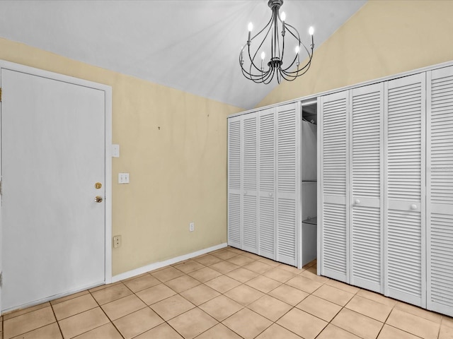 unfurnished dining area with light tile patterned floors, lofted ceiling, and an inviting chandelier