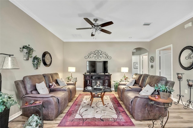 living room featuring ceiling fan, ornamental molding, and light wood-type flooring