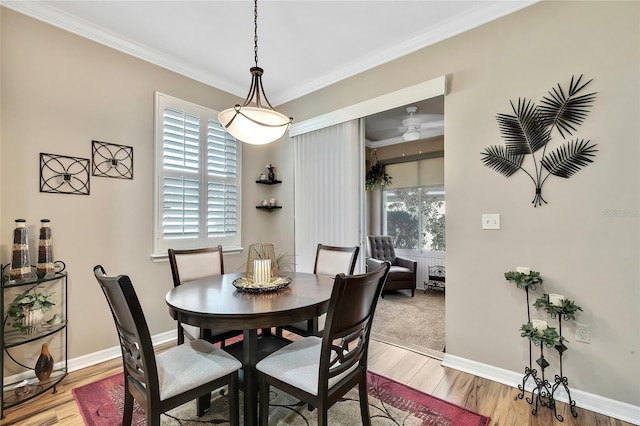 dining space featuring light hardwood / wood-style flooring, ceiling fan, and crown molding