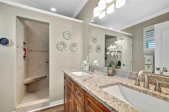 bathroom with hardwood / wood-style flooring, vanity, ornamental molding, and tiled shower