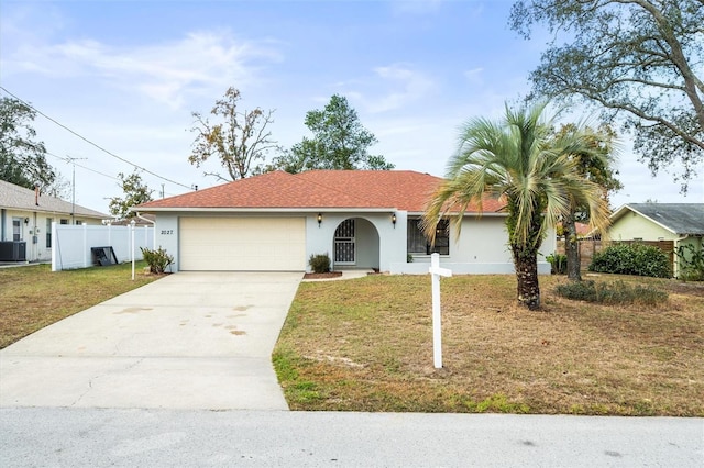 ranch-style home with a garage, central AC, and a front lawn