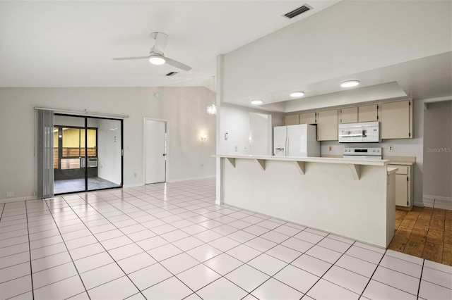 kitchen featuring white appliances, light tile patterned floors, a kitchen breakfast bar, ceiling fan, and cream cabinets