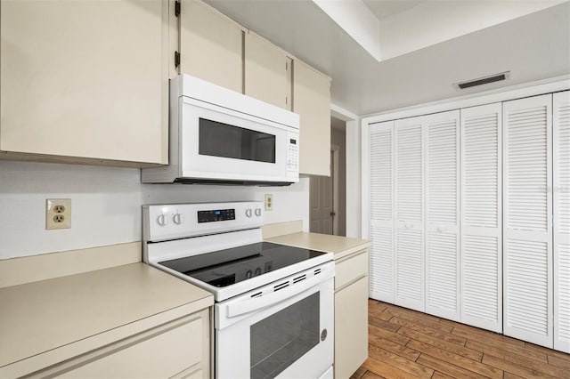 kitchen with white cabinets, white appliances, and light wood-type flooring