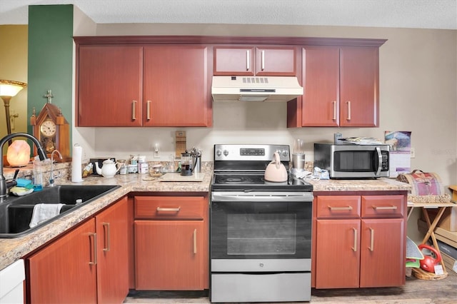 kitchen featuring appliances with stainless steel finishes, a textured ceiling, light hardwood / wood-style floors, and sink