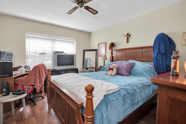 bedroom featuring a textured ceiling, ceiling fan, and dark wood-type flooring