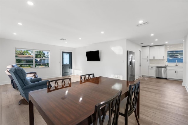 dining area featuring sink and light wood-type flooring