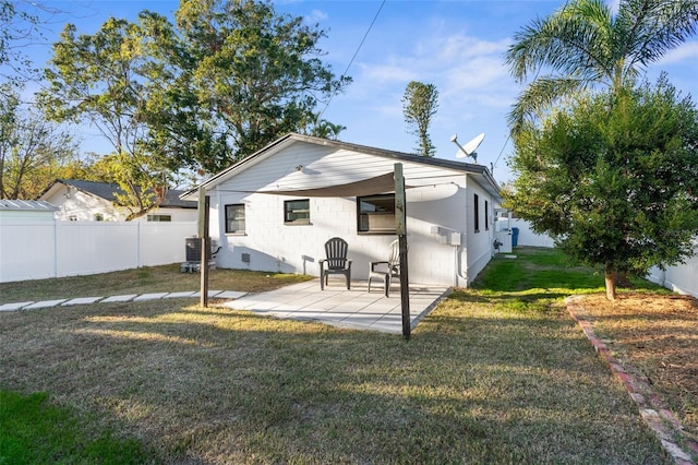 back of house with a yard, central AC unit, and a patio area