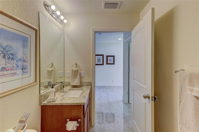 bathroom with a textured ceiling and vanity