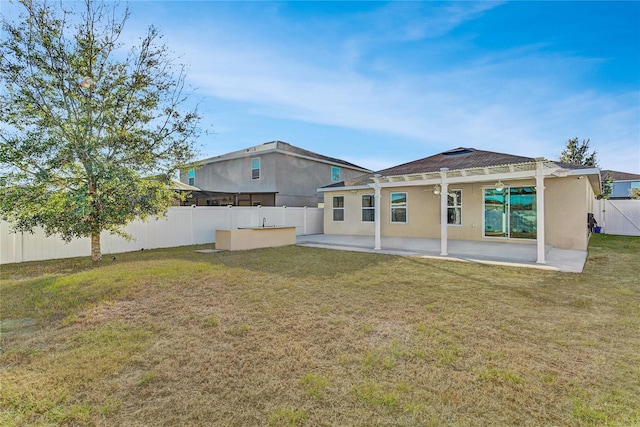 back of property with a patio area and a yard