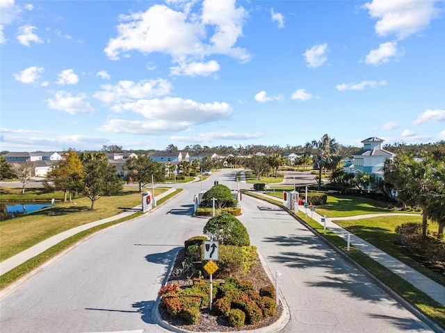 view of home's community featuring a water view and a lawn