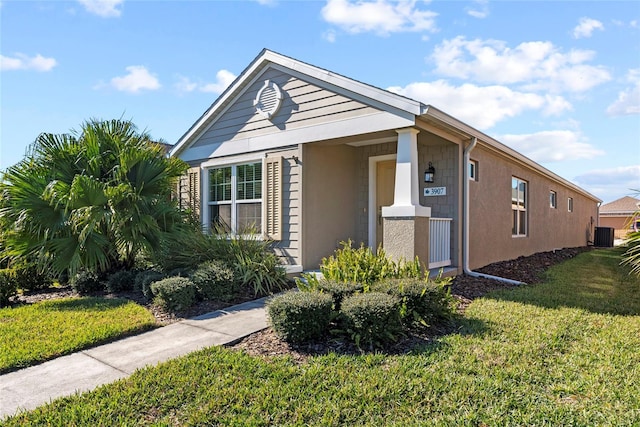 view of front of home featuring a front yard and central AC unit