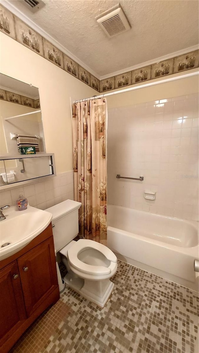 full bathroom with vanity, a textured ceiling, shower / bathtub combination with curtain, tile walls, and toilet