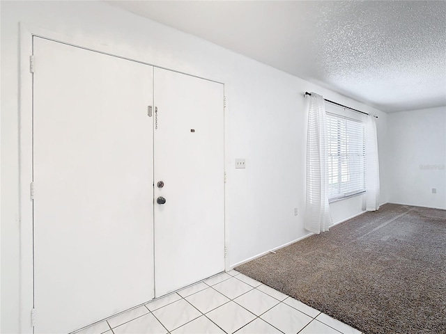 carpeted entryway featuring a textured ceiling