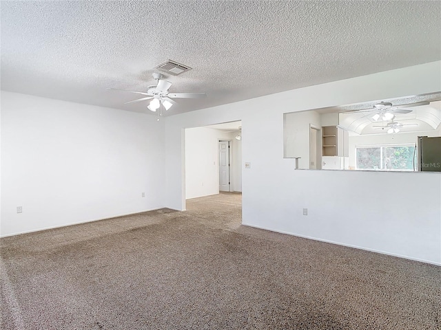 carpeted spare room featuring ceiling fan and a textured ceiling