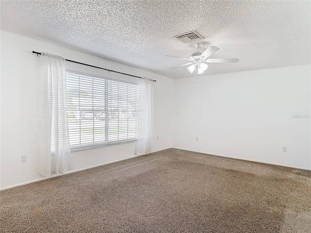 carpeted empty room with ceiling fan and a textured ceiling