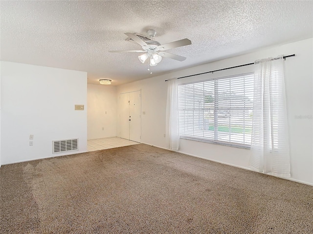 carpeted spare room with ceiling fan and a textured ceiling