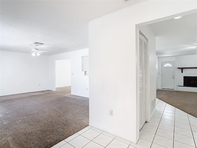 carpeted empty room featuring ceiling fan and a textured ceiling