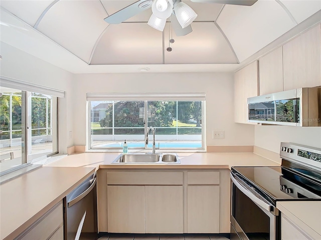 kitchen with appliances with stainless steel finishes, ceiling fan, a wealth of natural light, and sink