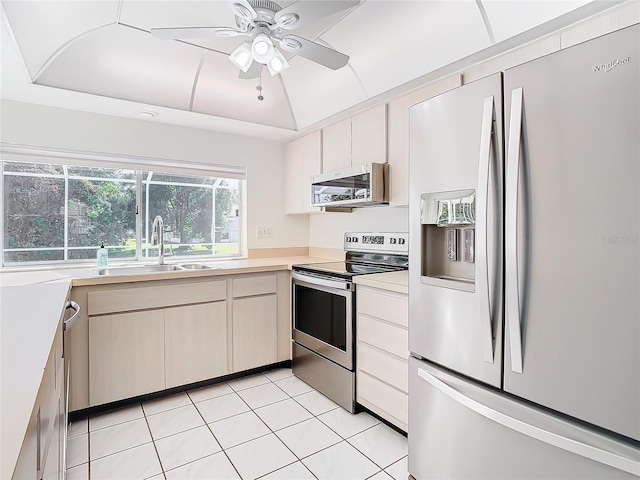 kitchen featuring ceiling fan, sink, stainless steel appliances, vaulted ceiling, and light tile patterned floors