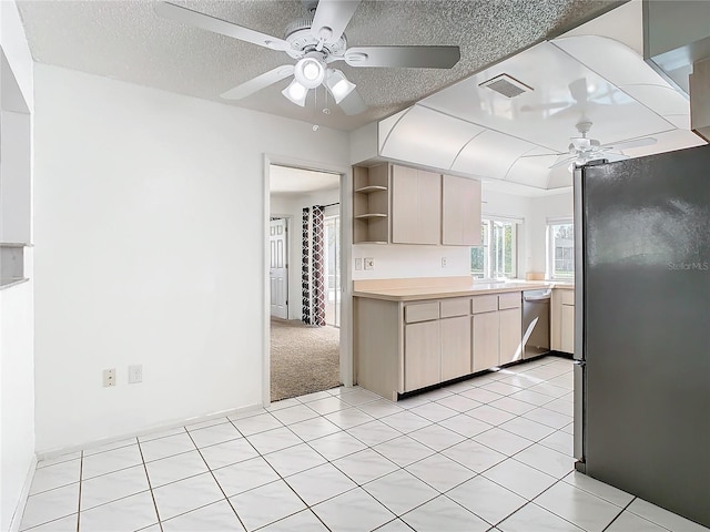 kitchen with ceiling fan, light brown cabinets, stainless steel appliances, a textured ceiling, and light carpet