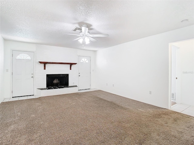 unfurnished living room with light carpet, a fireplace, ceiling fan, and a textured ceiling