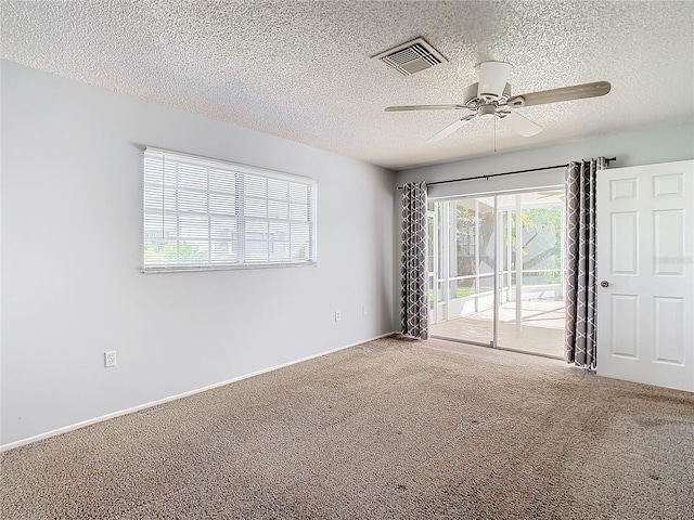 carpeted spare room featuring ceiling fan and a textured ceiling