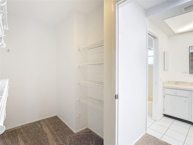 walk in closet with light tile patterned flooring