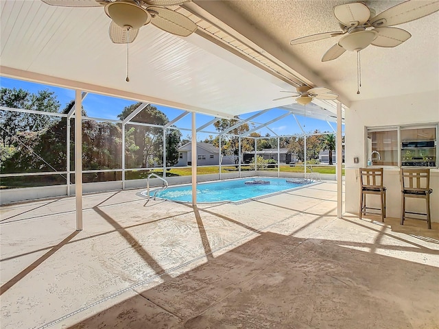 view of pool featuring a lanai, a patio area, and an outdoor wet bar