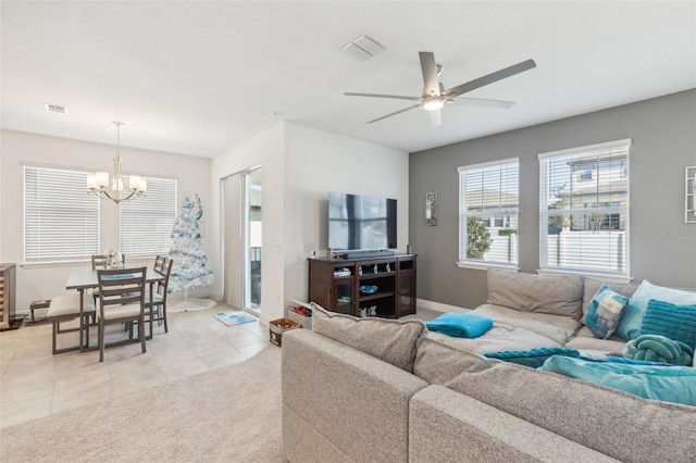 tiled living room with ceiling fan with notable chandelier
