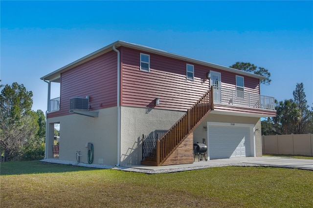 rear view of house with central AC, a balcony, a garage, and a lawn