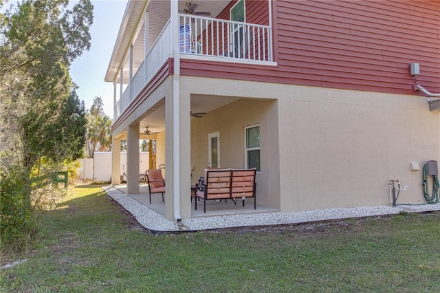 view of side of home featuring a yard, a balcony, and a patio area