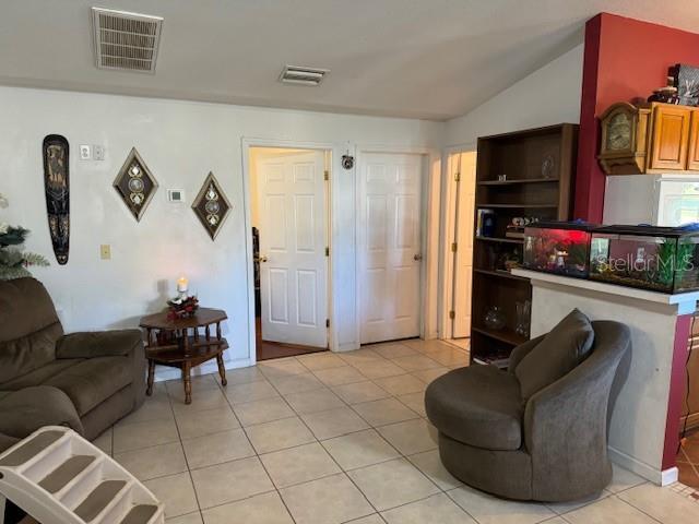 tiled living room featuring lofted ceiling