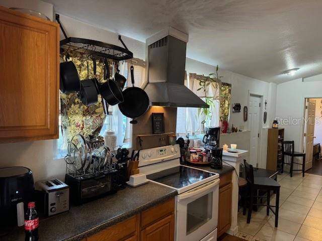 kitchen featuring light tile patterned flooring, range hood, and white electric stove