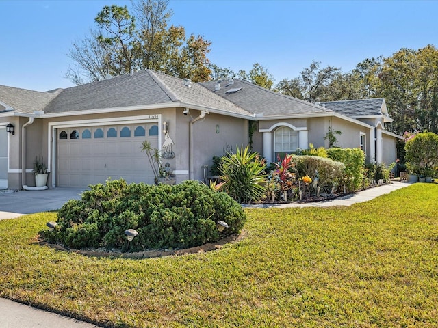 single story home with a garage and a front lawn