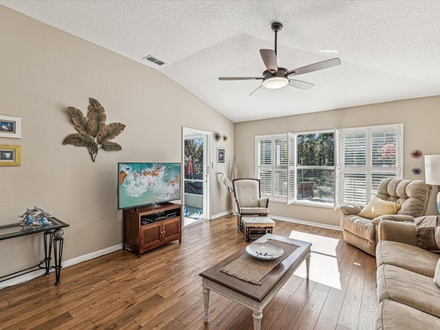 living room featuring ceiling fan, a textured ceiling, vaulted ceiling, and wood-type flooring