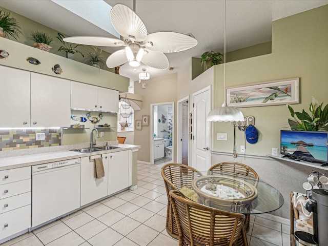 kitchen with sink, white cabinetry, light tile patterned floors, dishwasher, and ceiling fan