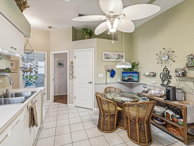 kitchen featuring white cabinetry, dishwasher, sink, and light tile patterned floors