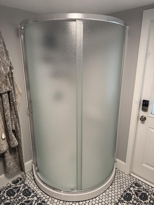 bathroom featuring tile patterned floors and a shower with door