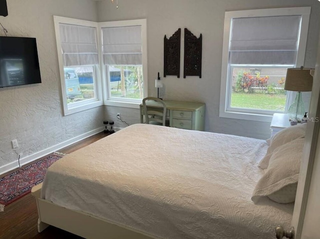 bedroom featuring multiple windows and hardwood / wood-style floors