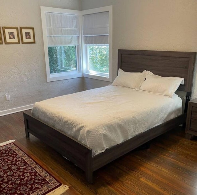 bedroom with dark hardwood / wood-style flooring