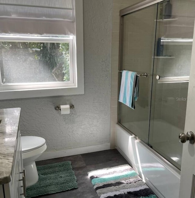 full bathroom featuring wood-type flooring, vanity, toilet, and bath / shower combo with glass door