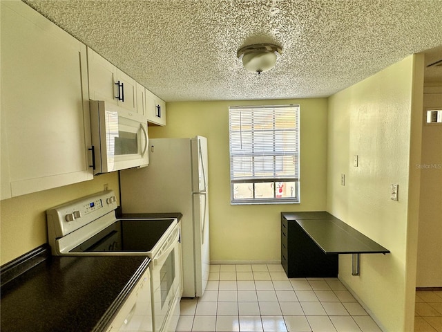 kitchen featuring white cabinets, white appliances, a textured ceiling, and light tile patterned floors