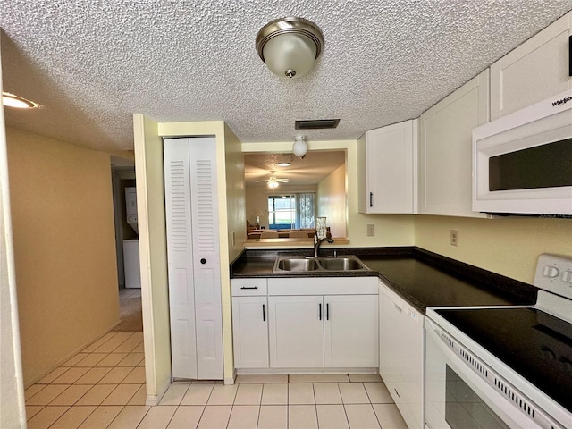 kitchen with white cabinets, light tile patterned floors, white appliances, and sink