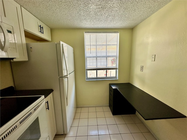 kitchen with a textured ceiling, white cabinets, light tile patterned floors, and white electric stove