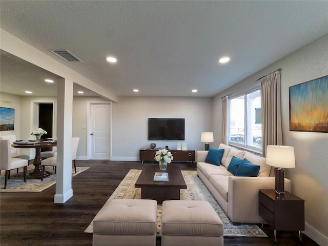 living room featuring dark hardwood / wood-style flooring and a textured ceiling