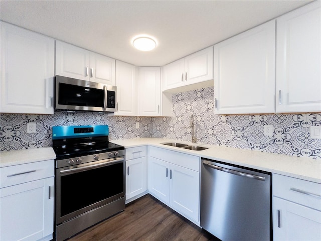 kitchen with dark hardwood / wood-style flooring, tasteful backsplash, stainless steel appliances, sink, and white cabinets