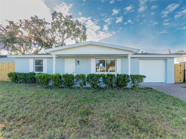 ranch-style house with a garage and a front lawn