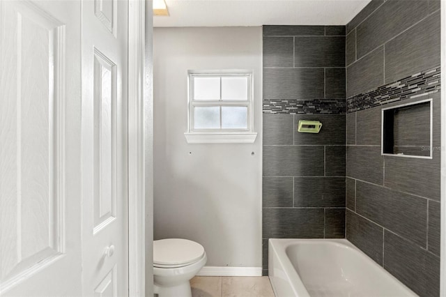 bathroom featuring toilet, tile patterned flooring, and tiled shower / bath