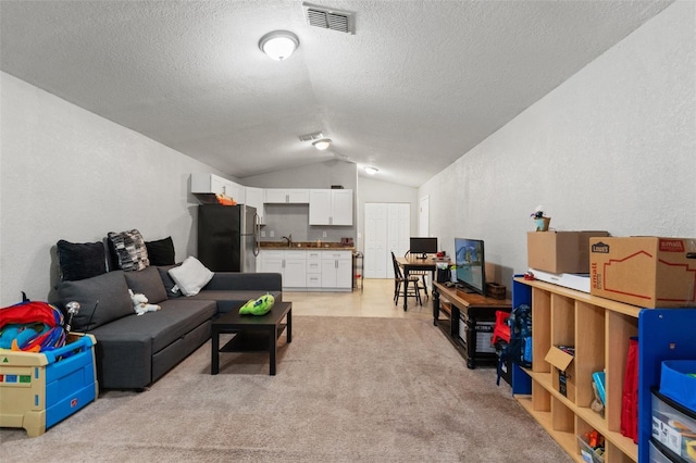 carpeted living room with sink, lofted ceiling, and a textured ceiling