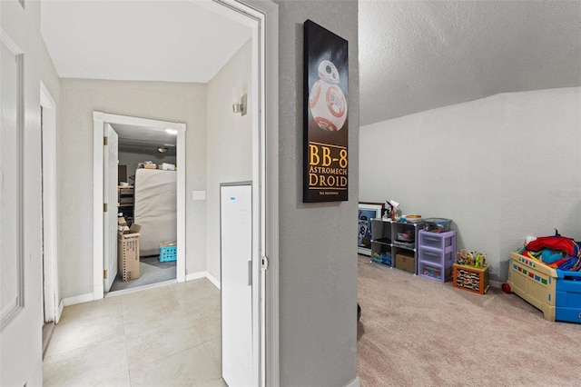 recreation room with a textured ceiling, light colored carpet, and lofted ceiling